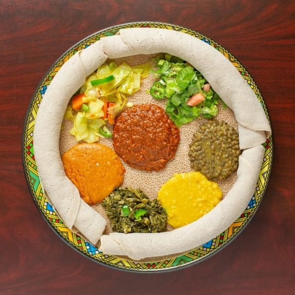 Elsi Ethiopian Restaurant's colorful platter of injera bread with various stews, vegetables, and lentils.