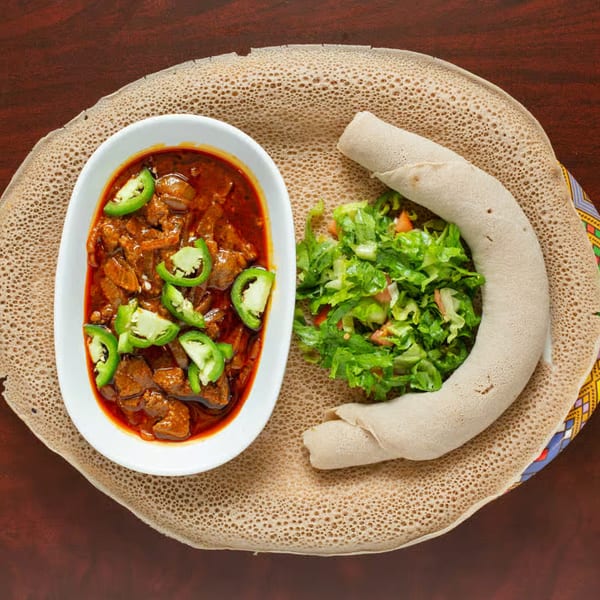 Elsi Ethiopian Restaurant's spicy meat stew with green peppers, salad, and injera bread.